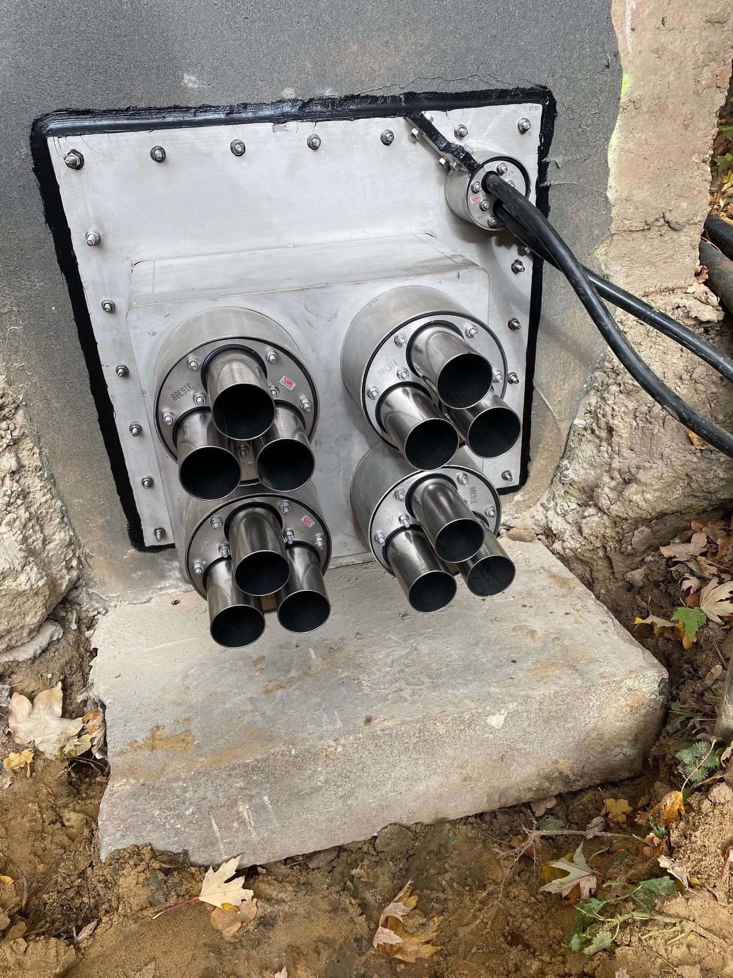 Mehrere Rohre liegen auf einer Betonoberfläche.