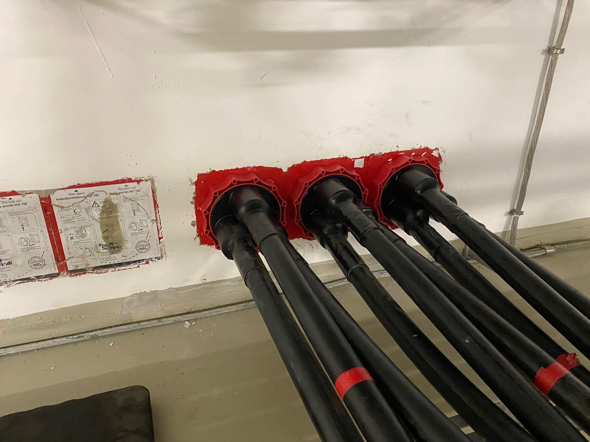 Ein Bündel elektrischer Leitungen ist mit einer Wand verbunden.