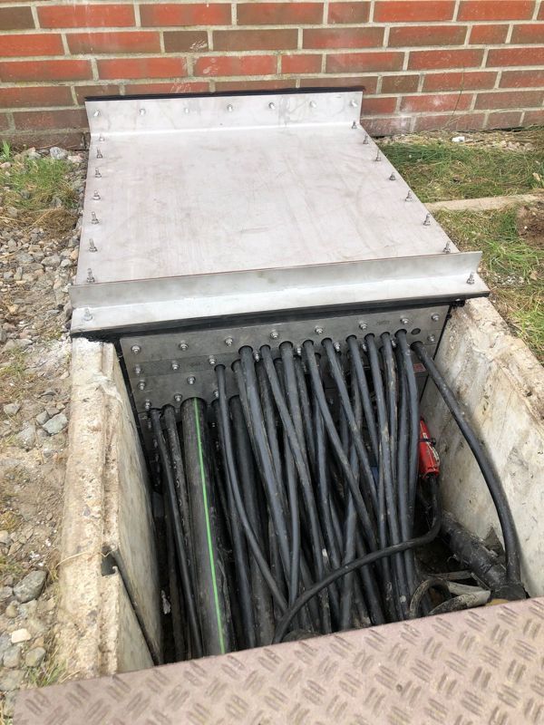 Ein Bündel Drähte kommt aus einem Loch im Boden.