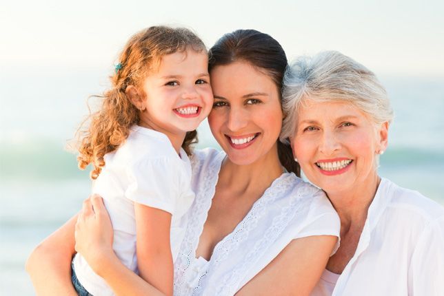 Dos mujeres y una niña posan para una foto en la playa.