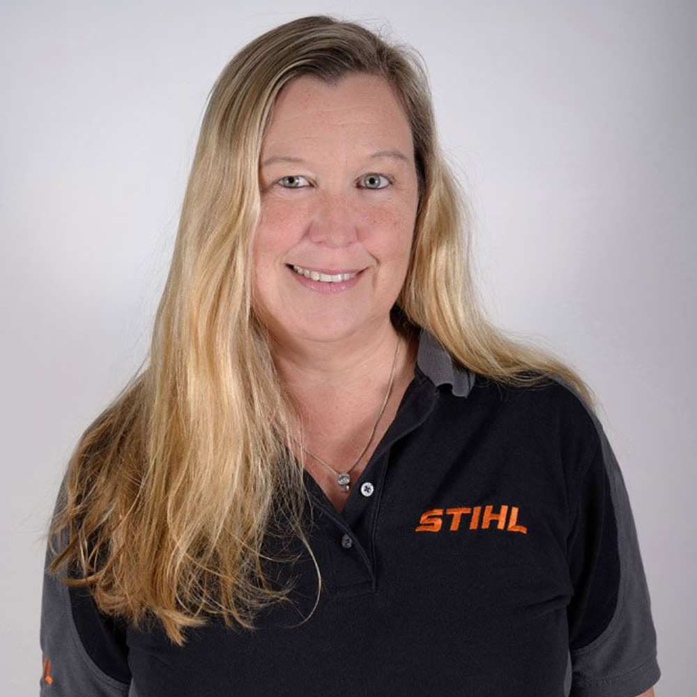Frau in einem schwarzen STIHL-Poloshirt lächelt in die Kamera.