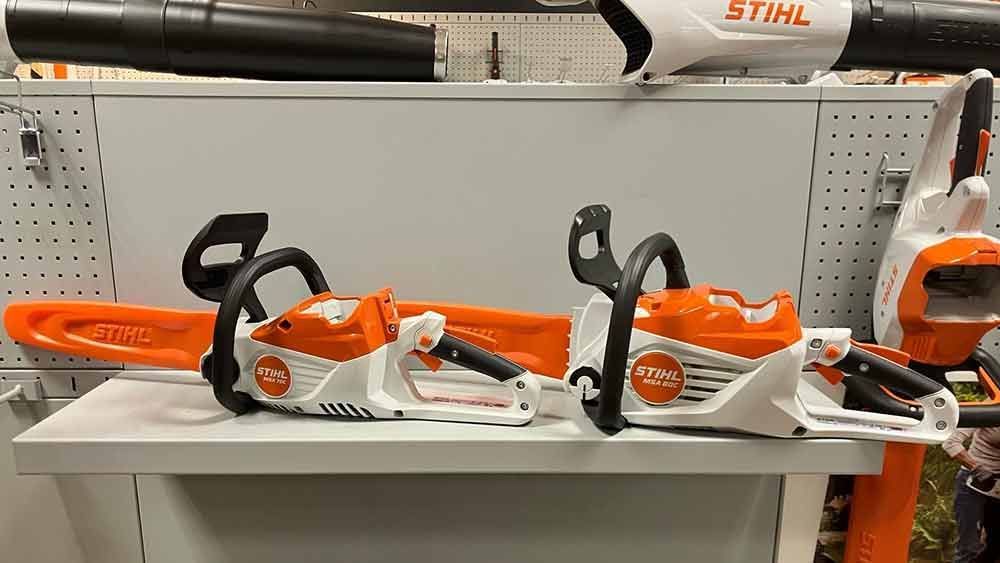 Auf einem weißen Tisch stehen zwei Stihl-Kettensägen.