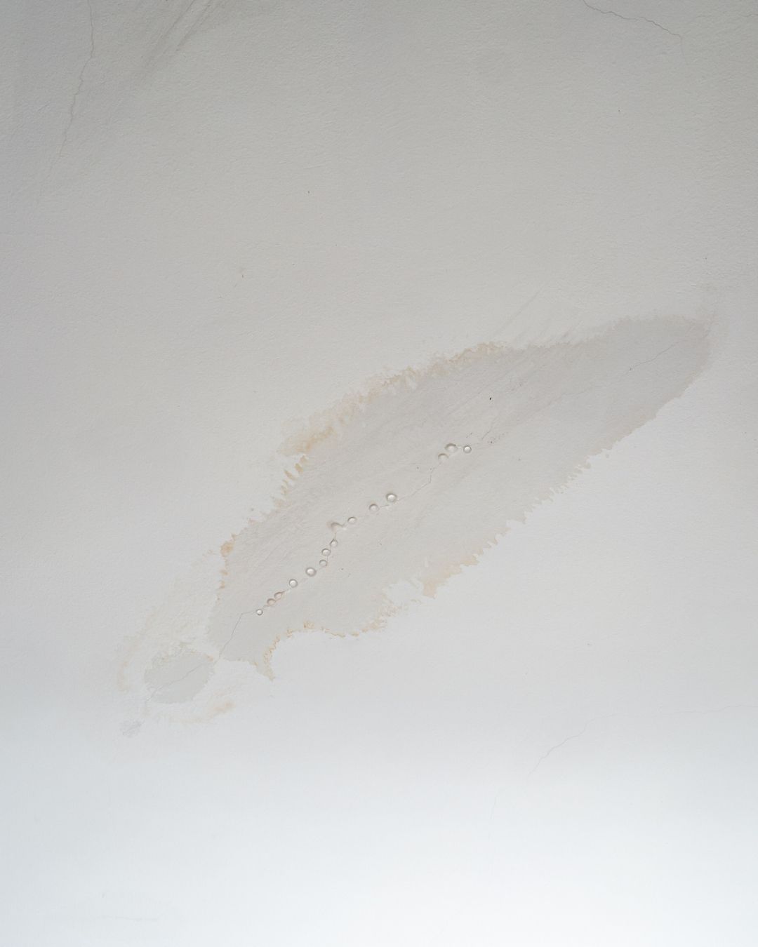 Una mancha de agua en un techo blanco liso.