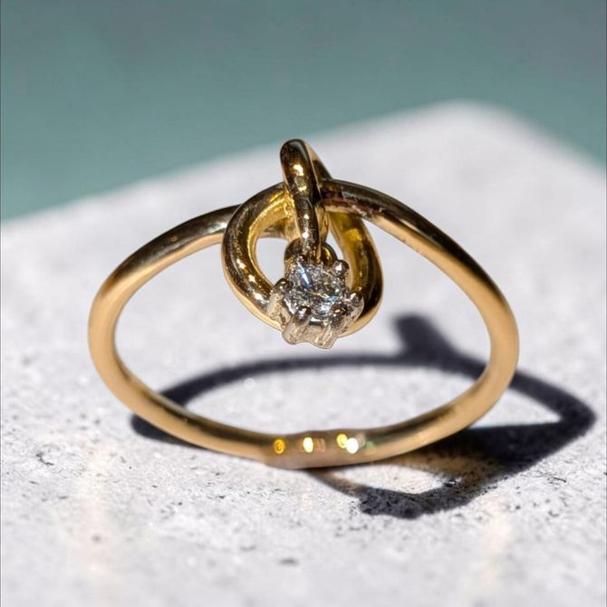 Création et réalisation dans notre atelier d'une bague noeud en or jaune 750 avec un diamant mobile. Possibilité de la réaliser en toute matière et avec un pierre de votre choix.