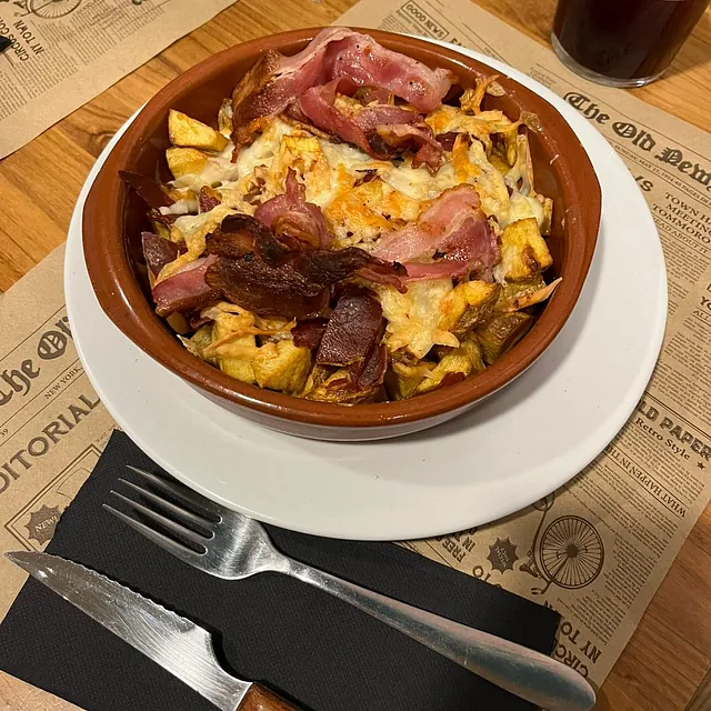 Un tazón de comida en un plato blanco con un tenedor.