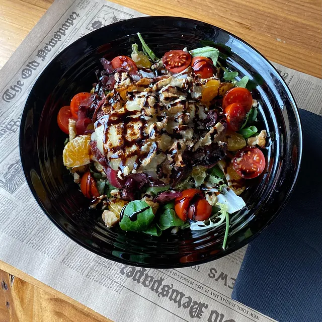Un plato de comida está sobre un periódico que dice periódico viejo