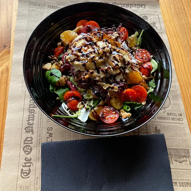 Un plato de comida está sobre un periódico que dice noticias viejas.