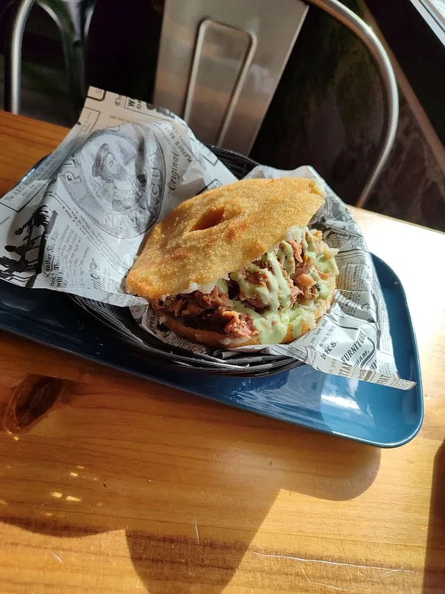 Un primer plano de un sándwich en una bandeja sobre una mesa.