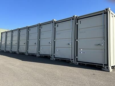 Auf einem Parkplatz steht eine Reihe von Lagercontainern.