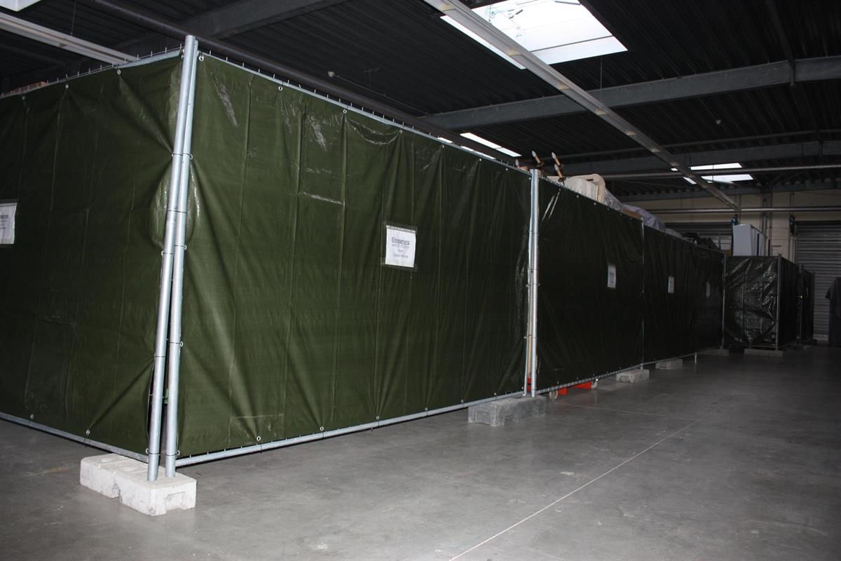 Ein Lagerhaus mit einer grünen Plane, die die Wände bedeckt