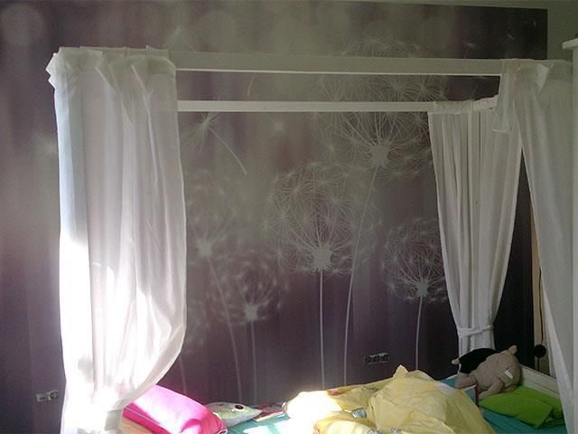 Ein Schlafzimmer mit einem Himmelbett mit weißen Vorhängen