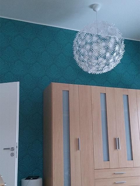 Ein Schlafzimmer mit Kleiderschrank und einem Kronleuchter, der von der Decke hängt