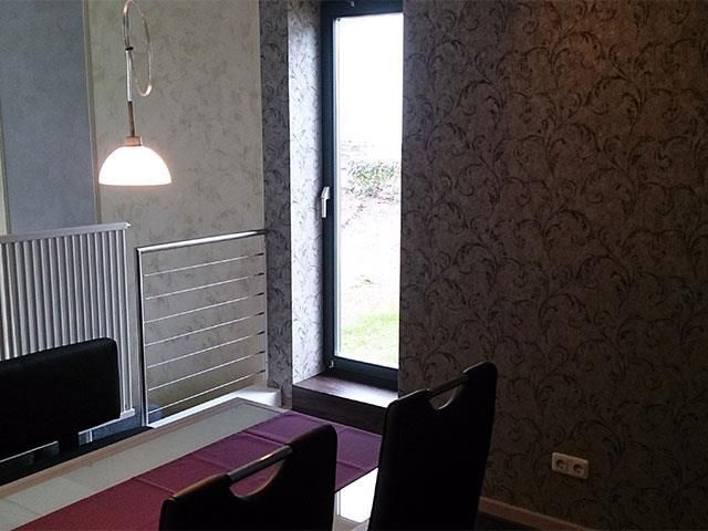 Ein Esszimmer mit Tisch und Stühlen und einem Fenster