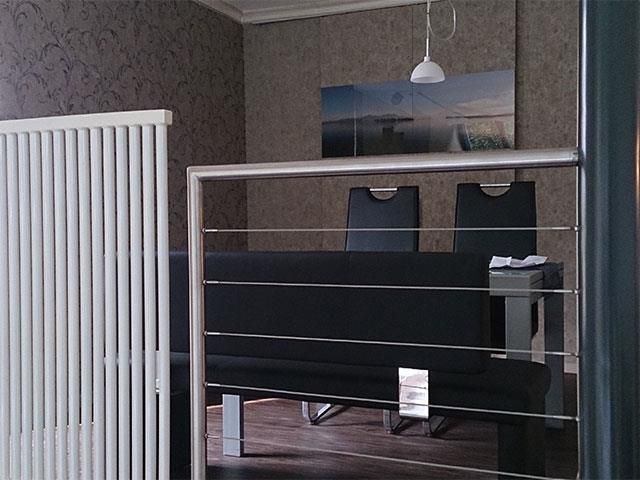 Ein Raum mit einem Edelstahlgeländer und einem Gemälde an der Wand