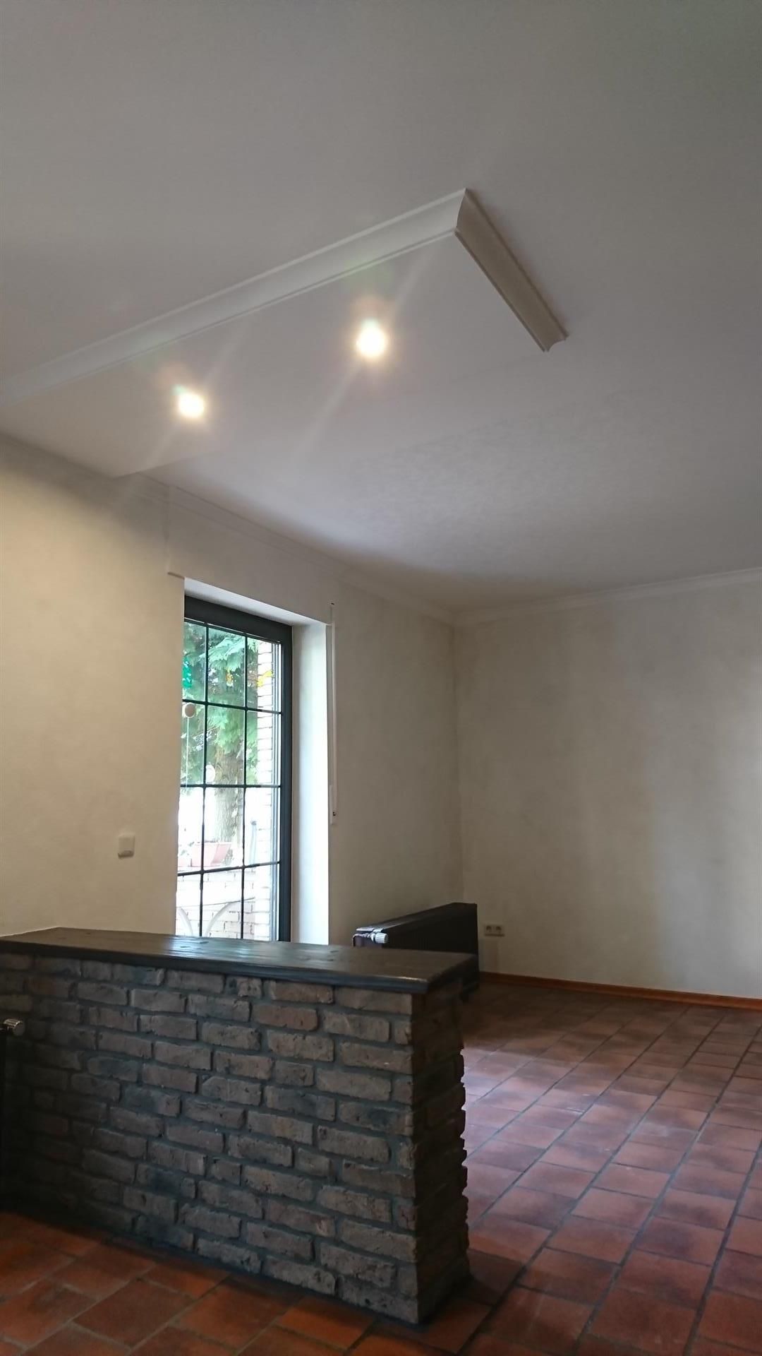 Ein leerer Raum mit einer Ziegelwand und einem Fenster.