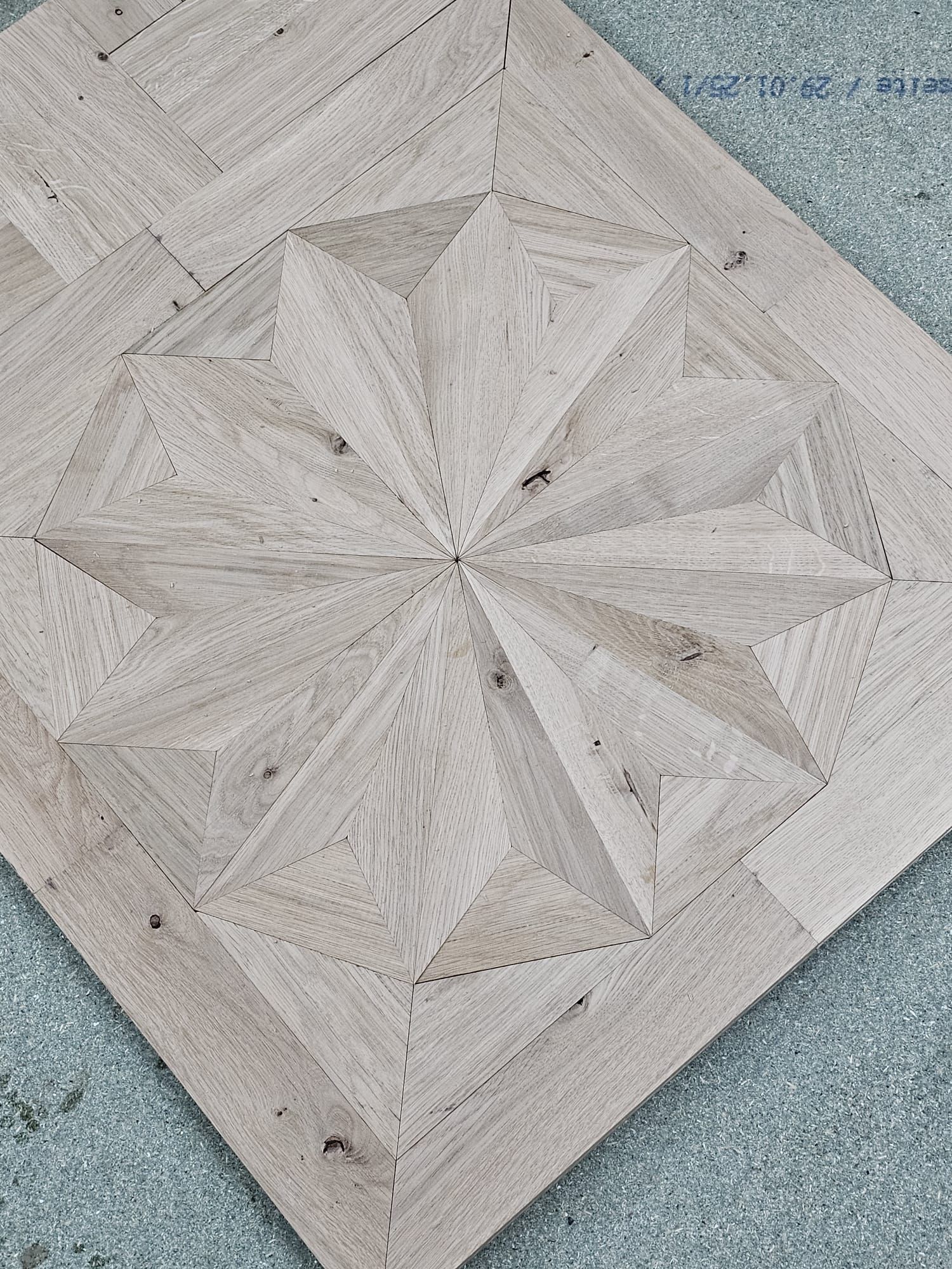 Geometrischer Holzboden mit Sternenmuster. Grau getönte Dielen.