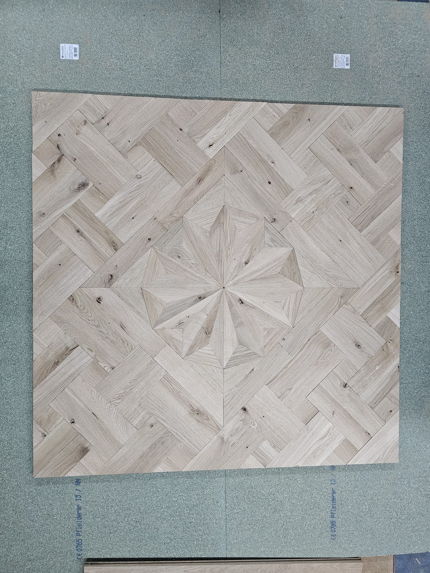 Holzfliese mit Sternendesign, umgeben von einem Fischgrätenmuster.