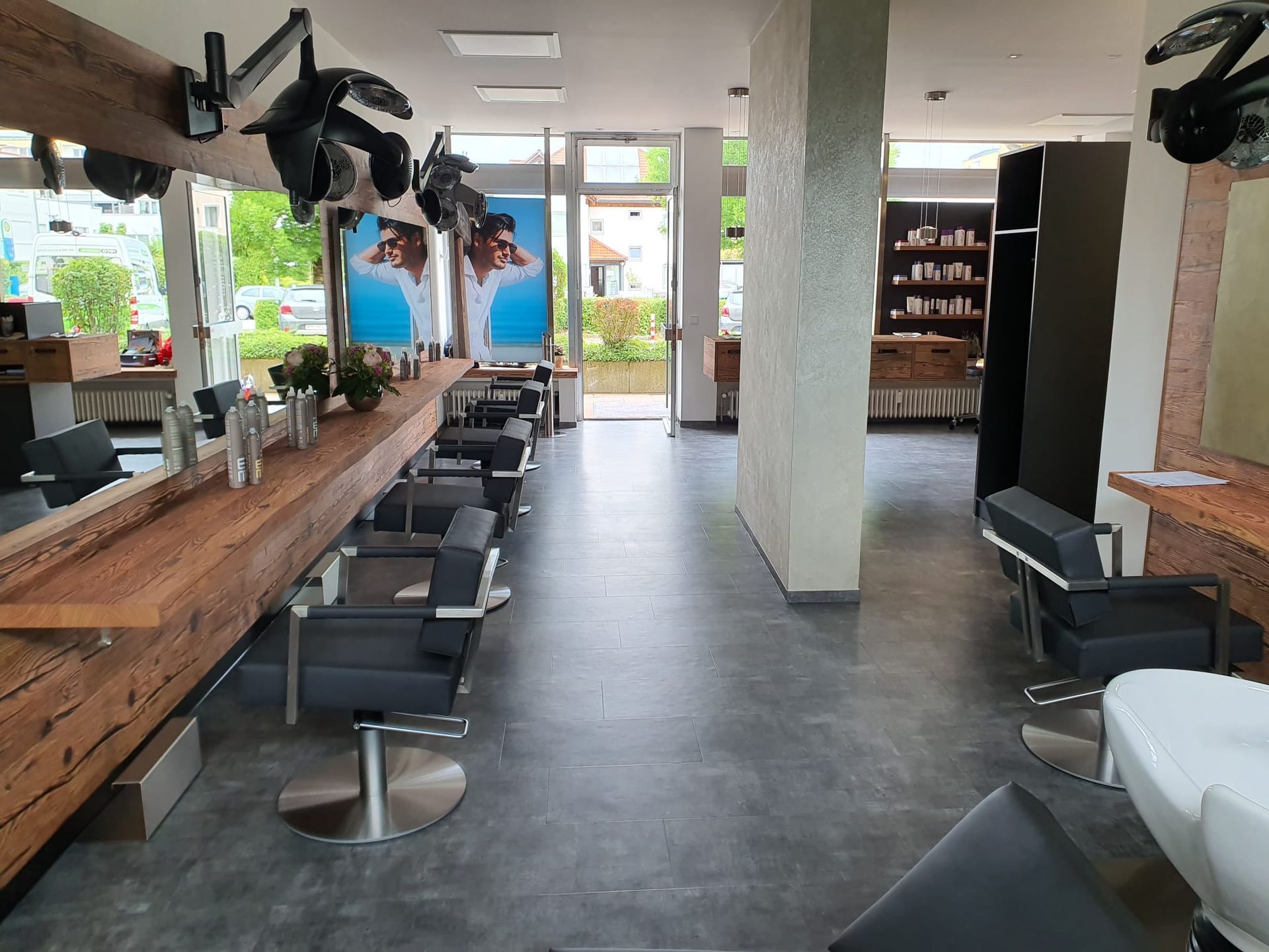 Friseursalon-Interieur mit Stühlen, Spiegeln und Styling-Geräten.