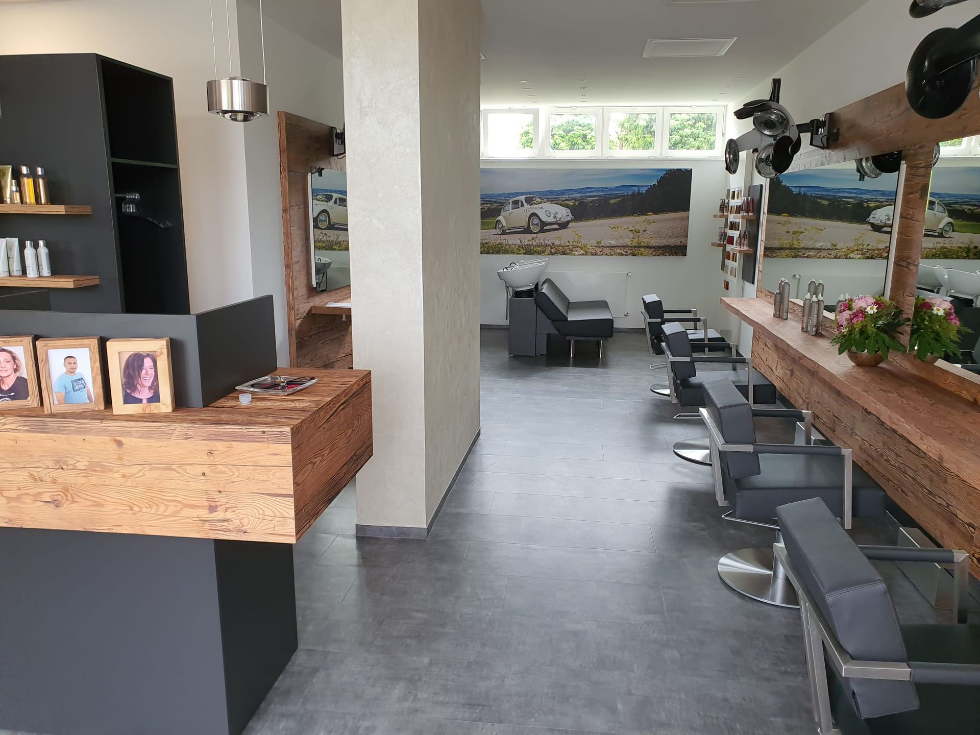 Friseursalon-Interieur mit Holzakzenten, Friseurstühlen und Spiegeln.