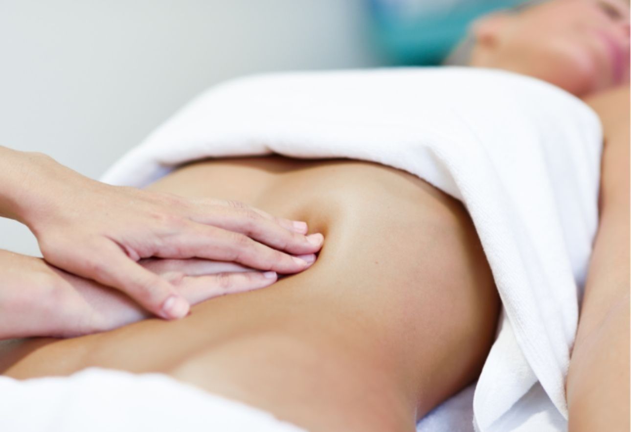 Una persona recibe un relajante masaje facial profesional en un ambiente de spa sereno y con iluminación tenue.