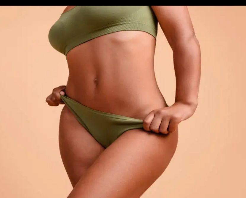 Un terapeuta realiza un masaje terapéutico de piernas a un cliente que yace sobre una camilla blanca en un entorno clínico.