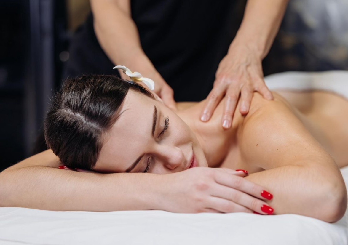 Una persona recibe un relajante masaje facial profesional en un ambiente de spa sereno y con iluminación tenue.