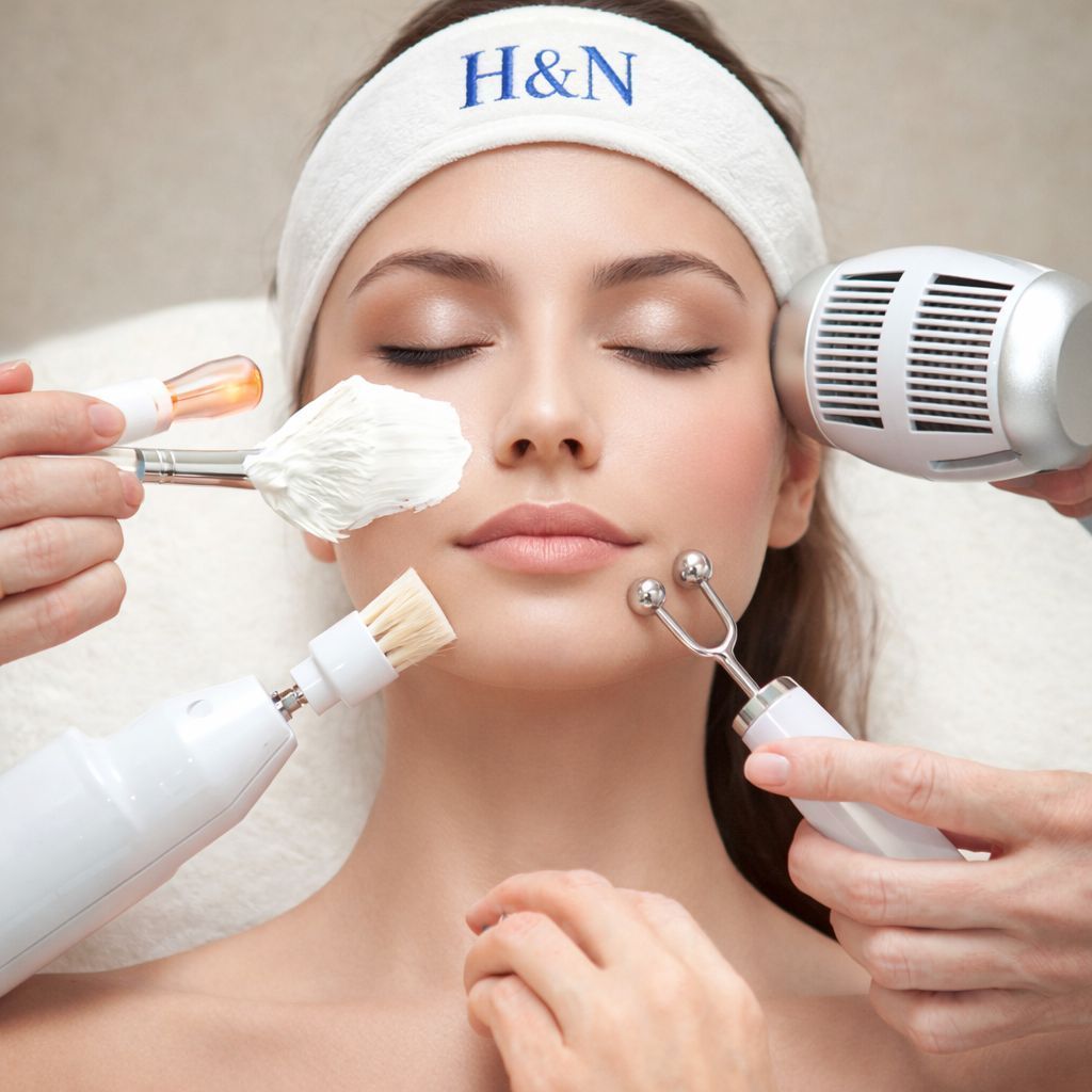 Una persona recibe un relajante masaje facial profesional en un ambiente de spa sereno y con iluminación tenue.