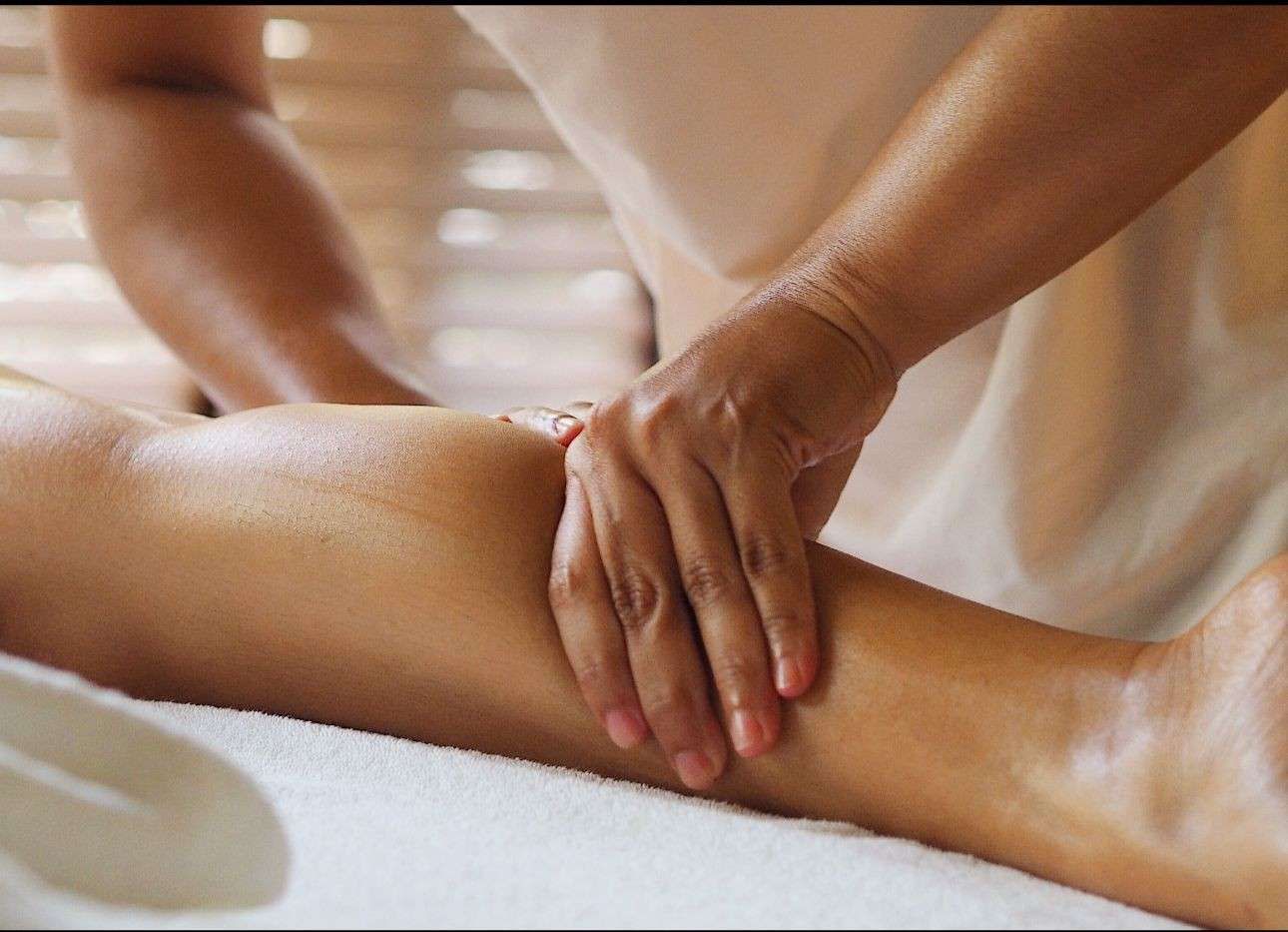 Una persona recibe un relajante masaje facial profesional en un ambiente de spa sereno y con iluminación tenue.