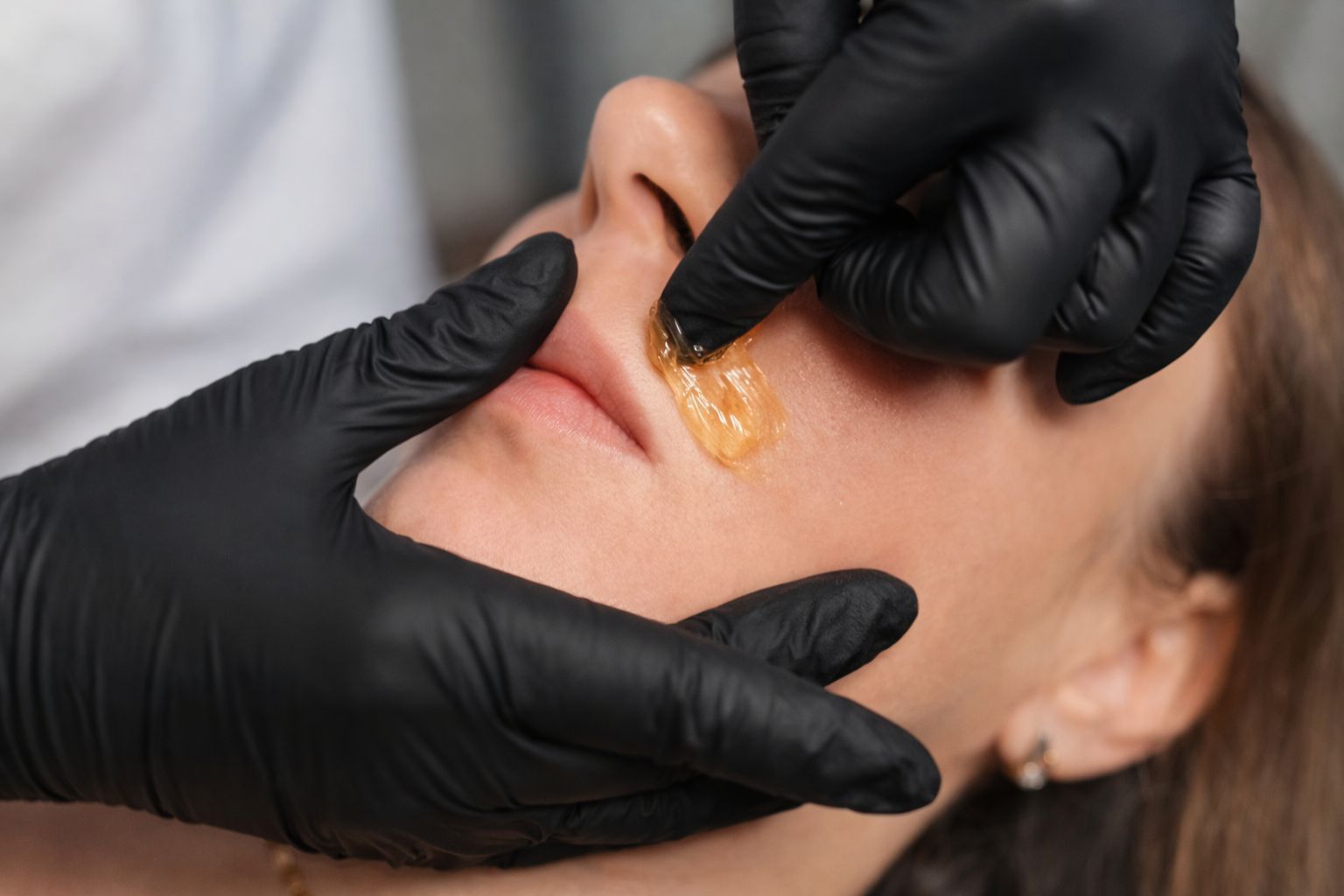 Una persona recibe un relajante masaje facial profesional en un ambiente de spa sereno y con iluminación tenue.