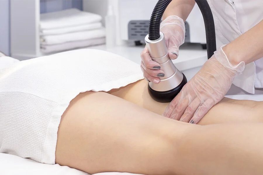 Una persona recibe un relajante masaje facial profesional en un ambiente de spa sereno y con iluminación tenue.