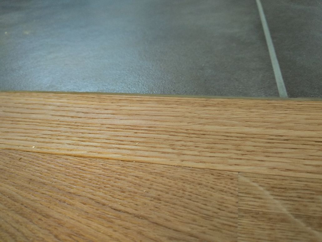 Eine Nahaufnahme eines Stücks Holz auf einem Fliesenboden.