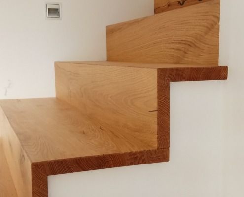 Eine Holztreppe mit einer weißen Wand dahinter