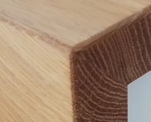 Eine Nahaufnahme eines Holzstücks, auf der die Maserung des Holzes zu sehen ist.