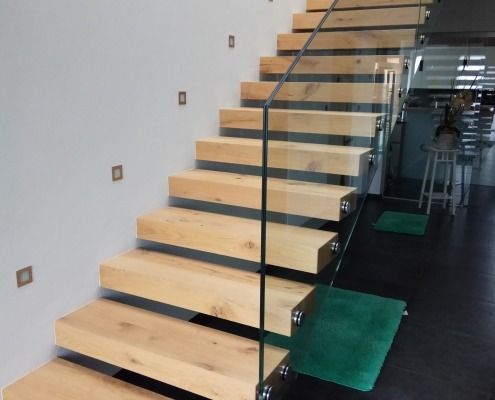 Eine Holztreppe mit einem Glasgeländer in einem Haus