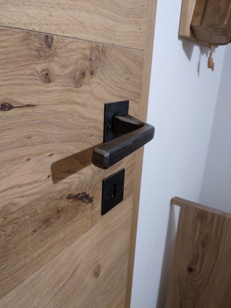 Eine Nahaufnahme einer Holztür mit einem Metallgriff.