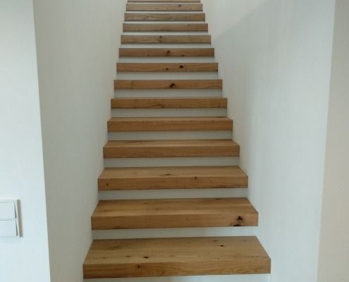 Eine Reihe von Holztreppen, die eine weiße Wand hinaufführen
