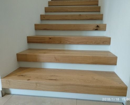 Eine Holztreppe mit einer weißen Wand dahinter