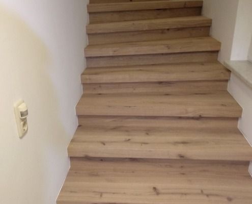 Eine Holztreppe führt in den zweiten Stock eines Hauses.