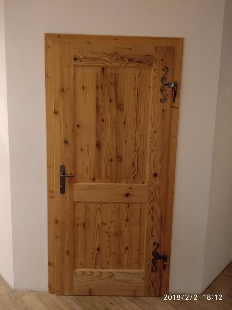 In einer Zimmerecke steht eine Holztür.