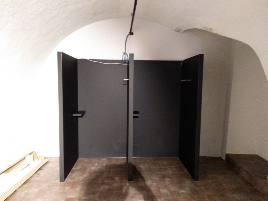 Zwei schwarze Türen sind in einem Raum mit gewölbter Decke geöffnet