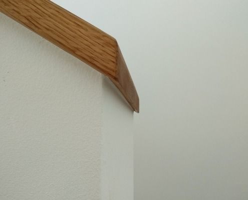 Eine weiße Wand mit einem Holzgeländer darauf