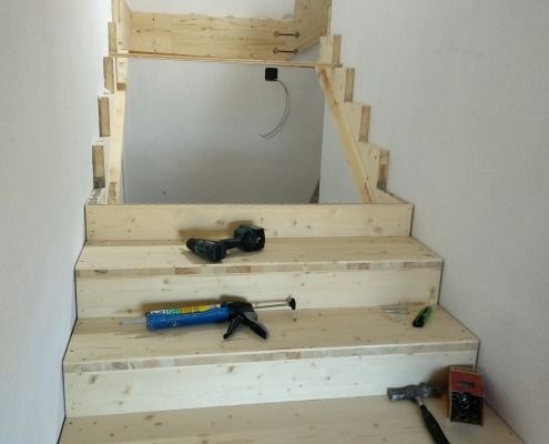 Eine im Bau befindliche Holztreppe mit Werkzeugen auf dem Boden
