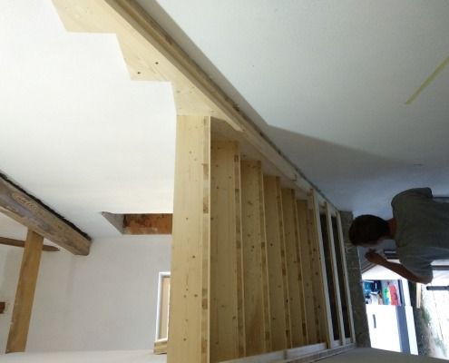 Ein Mann arbeitet an einer Holztreppe in einem Raum