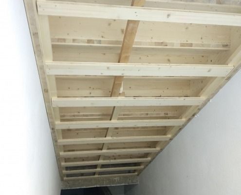 In einem Raum wird eine Holzdecke eingebaut.