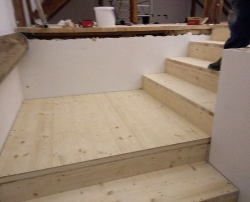 Eine Person, die auf einer Holztreppe steht