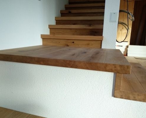 Eine Holztreppe mit einer weißen Wand dahinter