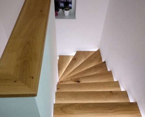Eine hölzerne Wendeltreppe mit Lichtern auf den Stufen
