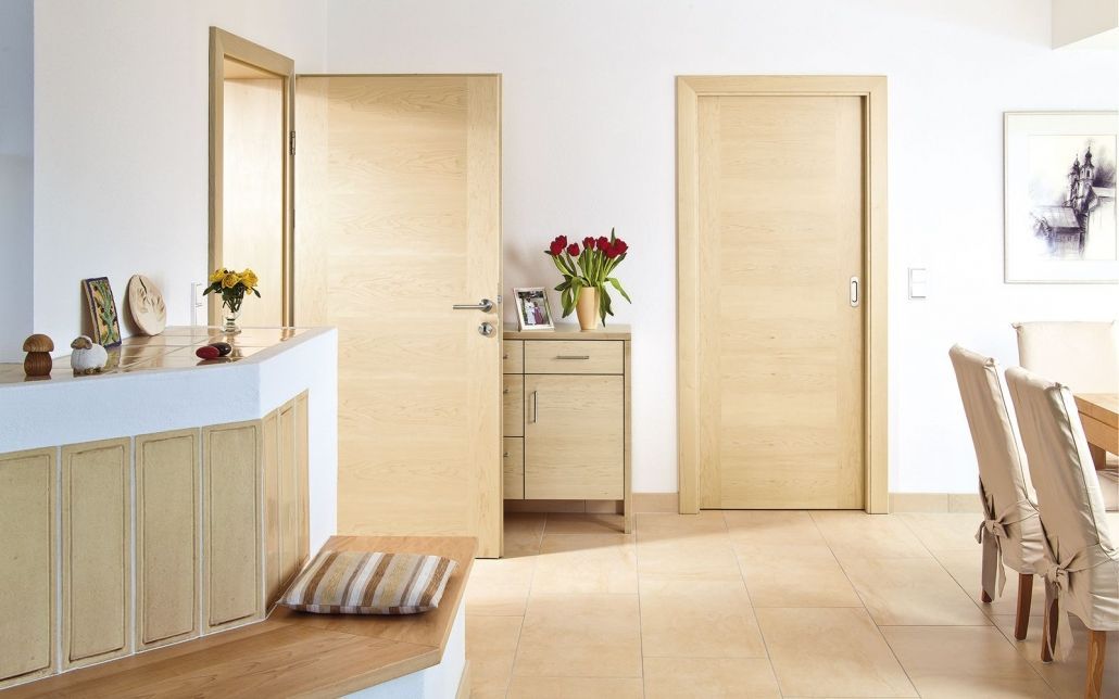 Ein Wohnzimmer mit Holztüren und ein Esszimmer mit Holzstühlen.