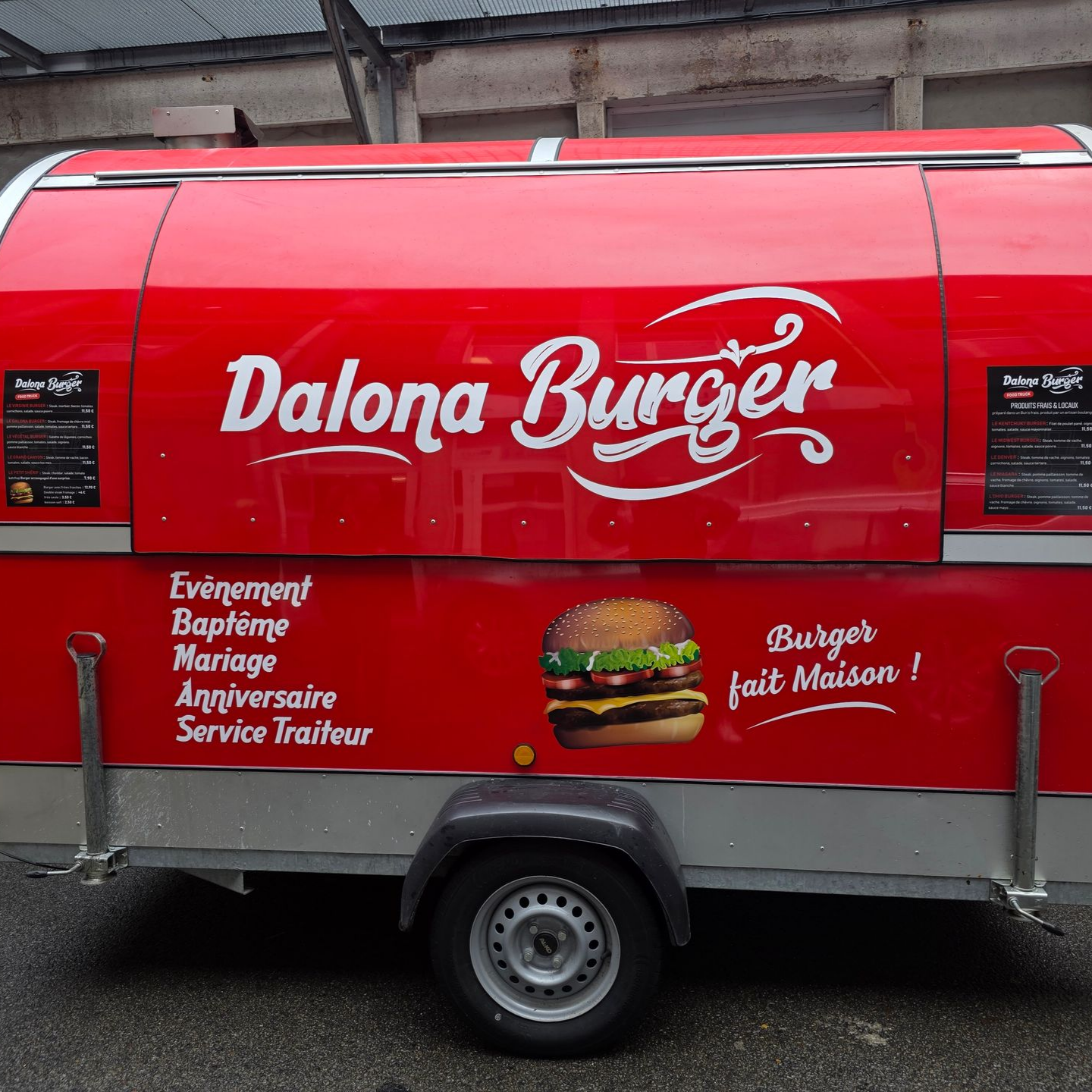 Camion-restaurant rouge arborant le logo DALONA BURGER, proposant des hamburgers et un service traiteur.