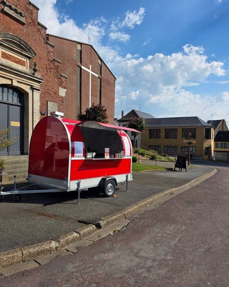 Le food truck de DALONA BURGER stationné près d'un bâtiment en briques.